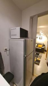 a microwave on top of a refrigerator in a room at Emplacement exceptionnel et rare Paris Suresnes longchamp in Suresnes