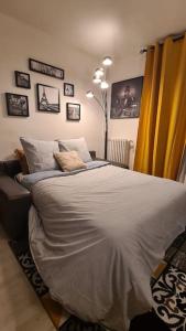 a bedroom with a large bed and a yellow curtain at Emplacement exceptionnel et rare Paris Suresnes longchamp in Suresnes