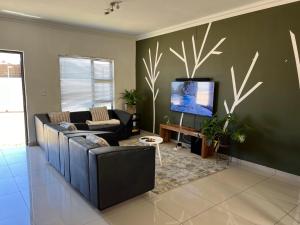 a living room with a couch and a flat screen tv at Apartment close to Golf Course! in Windhoek