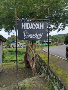 a sign for ahazi homesteadery on the side of a road at Hidayah homestay in Kelimutu