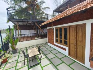 a patio with two chairs and a table on a house at East West Beach Resorts in Varkala