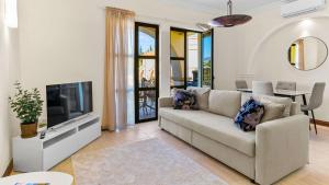 Una sala de estar con un sofá y un televisor. en Beautiful Apartment APJ03 - Anesi, Aphrodite Hills, en Kouklia