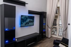 Napoli Center Suite Palmentieri في نابولي: غرفة معيشة مع تلفزيون بشاشة مسطحة على جدار