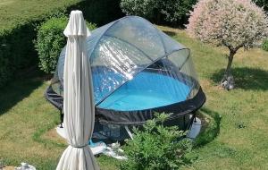 - un bain à remous dans une tente dans une cour avec un parasol dans l'établissement Sweet Home En Gaume, à Chiny