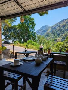 un patio con mesa y vistas a la montaña en Kai Kazee Ella, en Ella