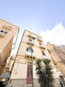 een hoog gebouw met een straatlicht ervoor bij Libertà House in Palermo