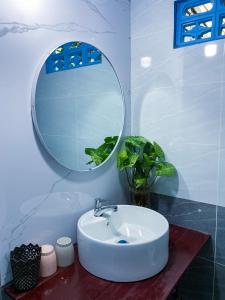 ein Bad mit einem Waschbecken und einem Spiegel in der Unterkunft Dorry Le's House in Gia Nghĩa