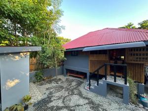 ein kleines Haus mit rotem Dach und Hof in der Unterkunft Amakan Beachfront Private House Bataan in Bagac