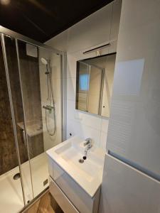 een witte badkamer met een wastafel en een douche bij Vakantiepark de Thijmse Berg in Rhenen