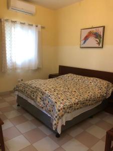 Hotel Bom Amigo في إنهامبان: غرفة نوم مع سرير في غرفة مع نافذة
