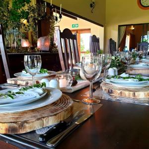 einen Tisch mit Tellern und Weingläsern darauf in der Unterkunft Silver Hill Lodge in Rev Estates
