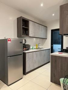 a kitchen with a stainless steel refrigerator and cabinets at Reizz Residence By Nexus Suites in Kuala Lumpur