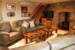 a living room with a couch and a table at Cnwc Y Boidy Llangrannog in Llangranog