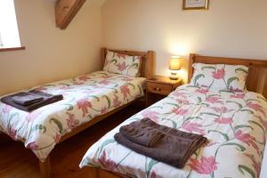 a bedroom with two beds and a purse on the bed at Cnwc Y Boidy Llangrannog in Llangranog