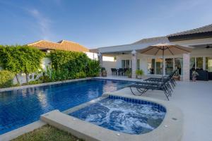 a swimming pool in front of a house at Orchid Paradise Homes Villa in Hua Hin