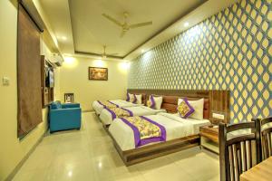 a bedroom with two beds and a blue chair at Hotel Smart Plaza Delhi Airport in New Delhi