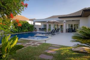 a backyard with a swimming pool and a house at Orchid Paradise Homes Villa in Hua Hin