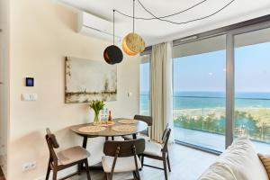 a dining room with a table and chairs and a view of the ocean at Wave - Sea View Resort&SPA 648A in Międzyzdroje