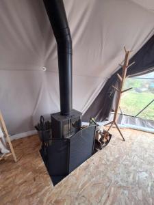 a black stove sitting in a tent at Bulle des Fagnes in Philippeville