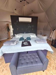 a bed in a tent with a blue tufted bedvisor at Bulle des Fagnes in Philippeville