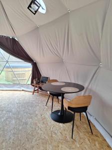 a tent with a table and chairs in it at Bulle des Fagnes in Philippeville