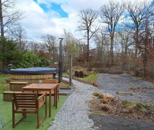 a picnic table and benches in a garden at Bulle des Fagnes in Philippeville