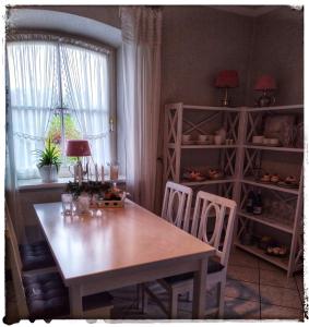 a dining room with a table and chairs and a window at Ferienwohnung Landidylle in Zodel +18 photos