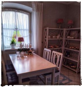 ein Esszimmer mit einem Tisch, Stühlen und einem Fenster in der Unterkunft Ferienwohnung Landidylle in Zodel