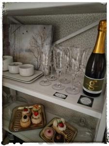 a bottle of wine and wine glasses on a shelf at Ferienwohnung Landidylle in Zodel