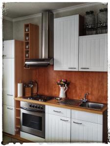 a kitchen with white cabinets and a stove and a sink at Ferienwohnung Landidylle in Zodel