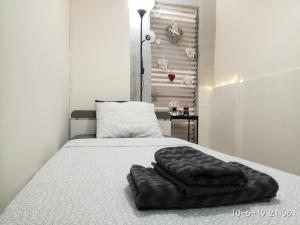 a bed with a black blanket on top of it at GEORGIA APARTMENT ATHENS AIRPORT in Artemida