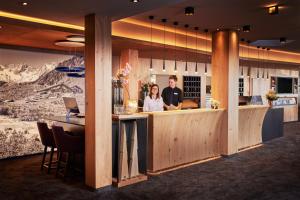 two people standing at a bar in a restaurant at Alpinresort Stubaierhof ****s in Fulpmes