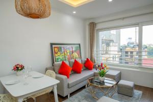 uma sala de estar com um sofá e uma mesa com almofadas vermelhas em Sumitomo 6 Apartment _ No 12 lane 523 Kim Ma street em Hanói