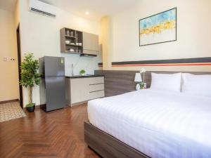 een slaapkamer met een groot wit bed en een keuken bij CENTRAL BOUTIQUE HOTEL in Da Nang