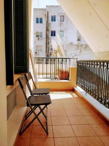 a chair on a balcony with a view of a building at Νεοκλασική Κατοικία στο Κέντρο in Mytilini