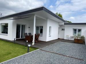 Casa blanca con terraza y mesa en Ferienhaus Lütt Hus An D'see, en Haffkrug