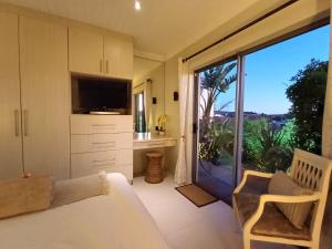 a bedroom with a bed and a large sliding glass door at Clanwilliam Oasis - Naturism, Boating, Hiking & more in Clanwilliam