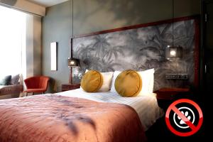 a bedroom with a large bed with a painting on the wall at The Southern Belle in Brighton & Hove