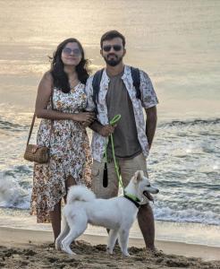 a man and a woman standing on the beach with a dog at DE LUMA Beach View in Puducherry