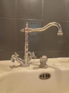 a bathroom sink with a silver faucet at Maison grande terrasse 5min plage in La Barre-de-Monts