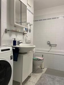 a white bathroom with a sink and a toilet at Nahe Airport BER/ Adlershof in Schönefeld