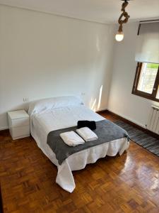 Chalet Galicia Landin في ريدونديلا: غرفة نوم عليها سرير وفوط