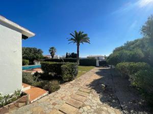 a house with a palm tree and a swimming pool at Villa Antonia in Cap d'en Font