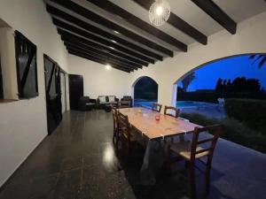 a dining room with a long table and chairs at Villa Antonia in Cap d'en Font