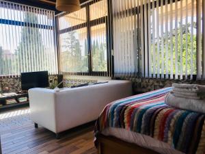 a bedroom with a tub and a bed and windows at Suite con vistas Alhambra in Granada