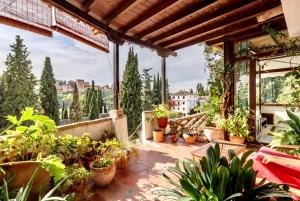 a patio with potted plants on a balcony at Suite con vistas Alhambra in Granada