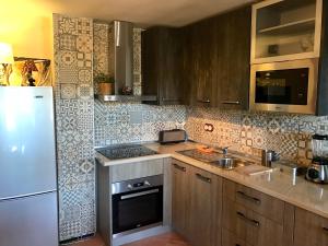 a kitchen with a white refrigerator and a sink at Suite con vistas Alhambra in Granada