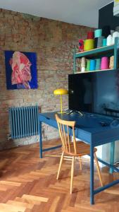 uma secretária azul com uma cadeira num quarto em Charming bedroom in artist studio em Londres