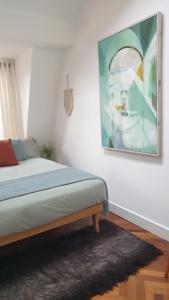 a bedroom with a bed and a painting on the wall at Charming bedroom in artist studio in London