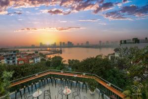 a view of a river and a city at sunset at Westlake Pearl Apartment & Hotel - By Pegasy Group in Hanoi